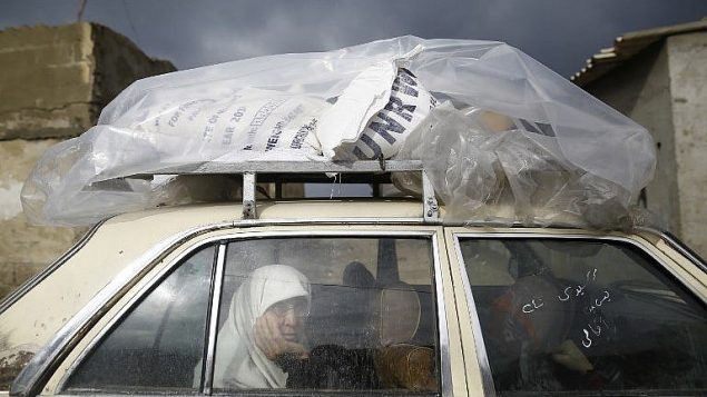 امرأة فلسطينية داخل سيارة بعد الحصول على مساعدات من قبل الأونروا في غزة، 17 يناير 2018 (AFP PHOTO / MOHAMMED ABED)