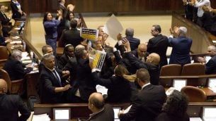 نواب كنيست عرب يرفعون لافتات احتجاجية بينما يحاول عناصر الأمن منعهم خلال خطاب نائب الرئيس الأمريكي مايك بنس في الكنيست الإسرائيلي في القدس، 22 يناير، 2018. ( / AFP PHOTO / POOL / Ariel Schalit)