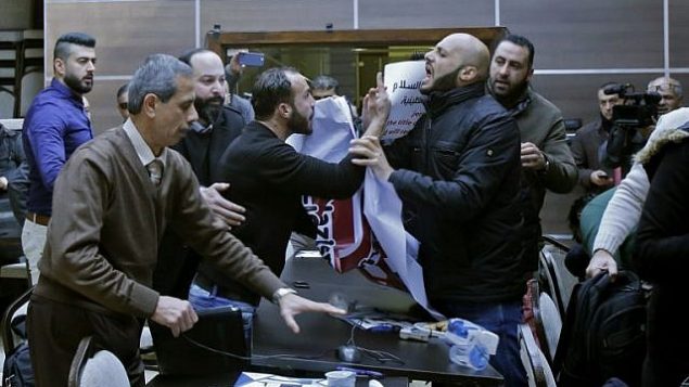 نشطاء فلسطينيون يقاطعون دورة لقاء بين أعضاء في وفد اقتصادي أمريكي ورئيس الغرفة التجارية لمحافظة بيت لحم، في مدينة بيت لحم في الضفة الغربية، 30 يناير، 2018. (AFP Photo/Musa Al-Shaer)