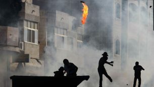 صورة توضيحية: متظاهر فلسطيني يلقي زجاجة حارقة خلال اشتباكات مع جنود اسرائيلية في قرية الرام بالقرب من رام الله، 27 سبتمبر 2013 (Issam Rimawi/Flash90)
