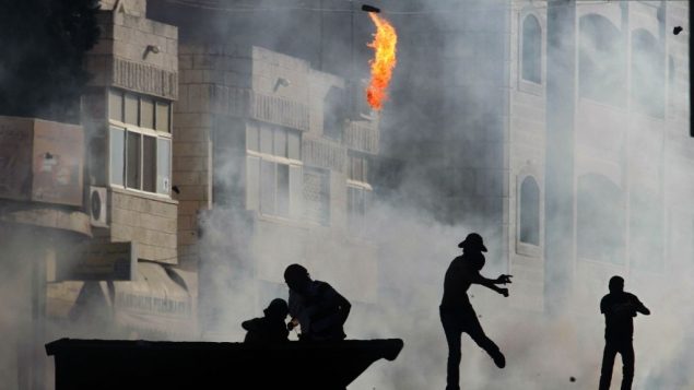 صورة توضيحية: متظاهر فلسطيني يلقي زجاجة حارقة خلال اشتباكات مع جنود اسرائيلية في قرية الرام بالقرب من رام الله، 27 سبتمبر 2013 (Issam Rimawi/Flash90)