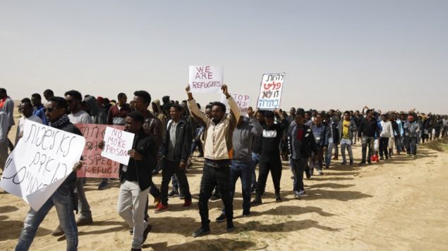 مهاجرون افريقيون يسيرون من سجن حولوت الى سجن سهرونيم في صحراء النقب في جنوب اسرائيل، 22 فبراير 2018 (AFP / MENAHEM KAHANA)