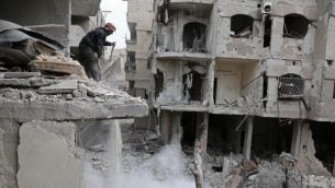 رجل سوري وسط الحطام بعد غارات جوية للنظام السوري في غوطة الشرقية، 22 فبراير 2018 (ABDULMONAM EASSA / AFP)