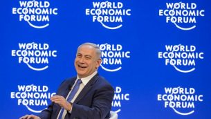 رئيس الوزراء بينيامين نتنياهو يضحك خلال مؤتمر في منتدى الاقتصاد العالمي السنوي في دافوس، 21 يناير، 2016. (AFP/FABRICE COFFRINI)