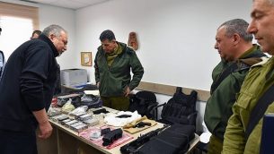 وزير الدفاع أفيغدور ليبرمان، من اليسار، يلقي نظرة على الأسلحة والمعدات العسكرية التي صودرت في عملية للجيش الإسرائيلي في الخليل، إلى جانب قائد المنطقة الوسطى المنتهية ولايته روني نوما، خلال جولة في مدينة الخليل، 27 فبراير، 2018. (Ariel Hermoni/Defense Minister)