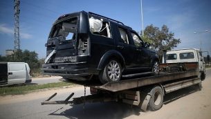 مركبة فلسطينية تضررت في انفجار وقع بالقرب من موكب رئيس وزراء السلطة الفلسطينية رامي الحمد الله، يجري العمل على نقلها في مدينة بيت حانون في شمال الضفة الغربية، 13 مارس، 2018. (AFP Photo/Mohammed Abed)