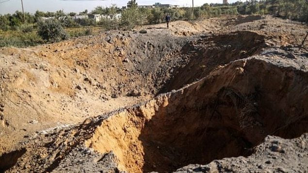 رجل فلسطيني يتفقد موقع غارة جوية إسرائيلية في مدينة غزة، 18 مارس، 2018. (AFP/Mahmud Hams)
)