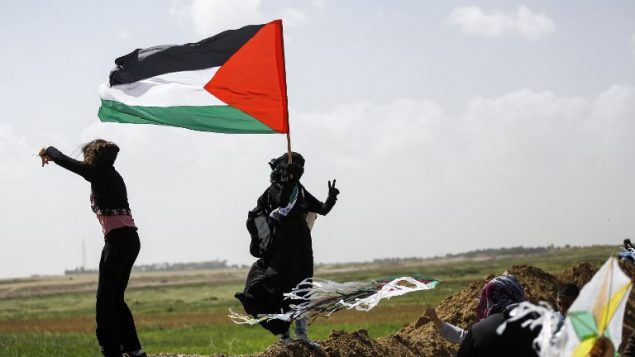 نساء فلسطينيات يطيرن طائرات ورق بألوان العلم الفلسطيني خلال مظاهرة قبل يوم الارض، في مدينة خيام واقعة بالقرب من الحدود بين اسرائيل وغزة، 29 مارس 2018 (AFP PHOTO / MOHAMMED ABED)