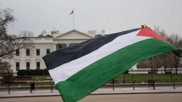 علم فلسطيني يرفرف أمام البيت الأبيض يوم 8 ديسمبر / كانون الأول 2017 في واشنطن العاصمة احتجاجا على إعلان الرئيس الأمريكي دونالد ترامب القدس عاصمة لإسرائيل. (AFP PHOTO / mari matsuri)