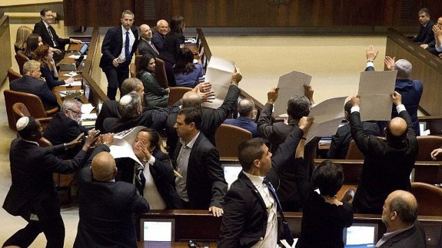 اعضاء كنيست من القائمة العربية المشتركة يرفعون لافتات عليها ’القدس عاصمة فلسطين’ خلال خطاب نائب الرئيس الامريكي مايك بنس في الكنيست، 22 يناير 2018 (AFP Photo/Pool/Ariel Schalit)