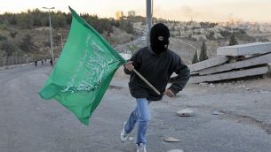 شاب من القدس يحمل علم حماس. (Nati Shohat/Flash90)