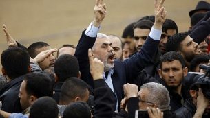 قائد حركة حماس في غزة يحيى السنوار (في مركز الصورة) يهتف شعارات ويرفع علامة النصر خلال زيارته لمدينة خيام احتجاجاية بالقرب من حدود غزة مع إسرائيل في 30 مارس، 2018، لإحياء ذكرى ’يوم الأرض’. (AFP PHOTO / Mohammed ABED)