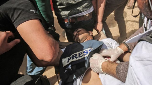 الصحفي الفلسطيني ياسر المرتجى بعد اصابته خلال اشتباكات مع القوات الإسرائيلية امام الحدود بني غزة واسرائيل، 6 ابريل 2018 (AFP/Said Khatib)
