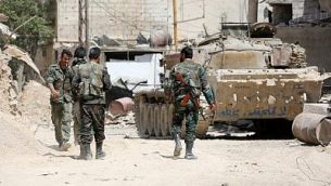 صورة تم التقاطها في 8 أبريل، 2018، يظهر فيها جنود في الجيش السوري يحتشدون في منطقة في الأطراف الشرقية لمدينة دوما، مع استمرار هجومهم آخر معاقل المتمردين الغوطة الشرقية.  (AFP Photo/Stringer)