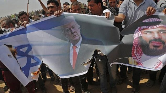 فلسطينيون يستعدون لإشعال النار بعلم إسرائيل وصور للرئيس الأمريكي دونالد ترامب وولي العهد السعودي محمد بن سلمان خلال مظاهرة في السياج الحدودي مع إسرائيل، شرق خان يونس في جنوب مدينة غزة، في 13 أبريل 2018. (AFP PHOTO / Thomas COEX)