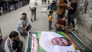 صورة تم التقاطها في 21 أبريل، 2018 تظهر رجالا يعدون ملصقا يحمل صورة البروفسور والعضو في حركة حماس، فادي محمد البطش (35 عاما) الذي قُتل في وقت سابق من اليوم في ماليزيا، خارج منزل عائلته في جباليا شمال الضفة الغربية. ( AFP PHOTO / MAHMUD HAMS)