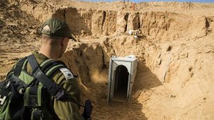 ضابط في الجيش الإسرائيلي ينظر إلى نفق الجهاد الإسلامي الفلسطيني المدمر، المؤدي من غزة إلى إسرائيل، قرب كيبوتس كيسوفيم جنوب إسرائيل في يناير / كانون الثاني 2018. (Jack Guez/AFP/POOL)