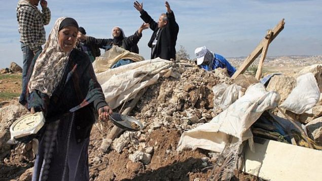 توضيحية: فلسطينيون يحاولون استخراج أغراضهم من حطام منزل بعد قيام جرافات الجيش الإسرائيلية بتدميره بالقرب من قرية سوسيا في الضفة الغربية في عام 2011. (Najeh Hashlamoun/Flash90)
