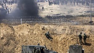 متظاهرون فلسطينيون يحرقون إطارات بالقرب من الحدود مع إسرائيل في قطاع غزة، كما يظهرون من الطرف الإسرائيلي من الحدود، 13 أبريل، 2018.  (Sliman Khader/Flash90)