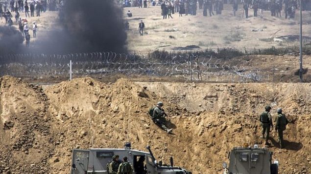 متظاهرون فلسطينيون يحرقون إطارات بالقرب من الحدود مع إسرائيل في قطاع غزة، كما يظهرون من الطرف الإسرائيلي من الحدود، 13 أبريل، 2018.  (Sliman Khader/Flash90)