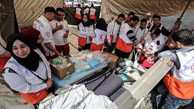 مسعفون فلسطينيون يتهيأون خلال مظاهرات  امام الحدود بين غزة واسرائيل بالقرب من خان يونس، شرقي مدينة غزة، 6 ابريل 2018 (SAID KHATIB / AFP)