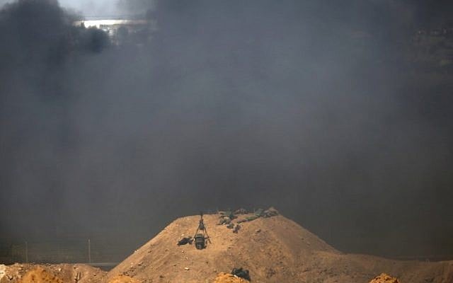 صورة التقطت من كيبوتس ناحال عوز الإسرائيلي مقابل الحدود بين اسرائيل وغزة، تظهر دخان اسود يتصاعد في الطرف الثاني من الحدود بهدف حجب رؤية الجنود الإسرائيليين خلال المظاهرات، 6 ابريل 2018 (AFP PHOTO / Jack GUEZ)