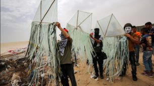 فلسطينيون يعدون طائرة ورقية قبل محاولة تطييرها مع مواد حارقة فوق السياج الحدودي مع إسرائيل، في خان يونس جنوبي قطاع غزة، 4 مايو، 2018. ( AFP PHOTO / SAID KHATIB)