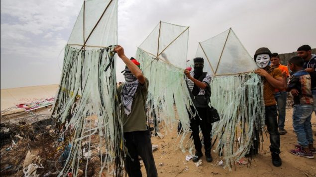 فلسطينيون يعدون طائرة ورقية قبل محاولة تطييرها مع مواد حارقة فوق السياج الحدودي مع إسرائيل، في خان يونس جنوبي قطاع غزة، 4 مايو، 2018. ( AFP PHOTO / SAID KHATIB)