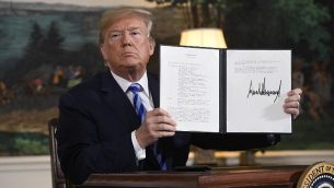 الرئيس الأمريكي دونالد ترامب يوقع على وثيقة تعيد فرض العقوبات على إيران بعد إعلانه عن انسحاب الولايات المتحدة من الاتفاق النووي مع إيران،  في غرفة الاستقبال الدبلوماسية في البيت الأبيض في العاصمة واشنطن، 8 مايو، 2018.  (AFP PHOTO / SAUL LOEB)