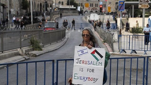 امرأة تحمل لافتة عند باب العامود قبل احتفاليات ’يوم القدس’ في ذكرى توحيد المدينة خلال حرب 1967، 13 مايو 2018 (Ahmad GHARABLI/AFP)