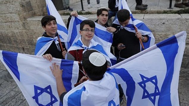 شبان يهود يحملون العلم الإسرائيلي خلال مسيرة للاحتفال ب’يوم القدس’ في ذكرى توحيد المدينة خلال حرب 1967، 13 مايو 2018 (Thomas COEX/AFP)