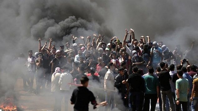 فلسطينيون يحرقون إطارات خلال اشتباكات مع قوات الامن الإسرائيلية بالقرب من الحدود بين قطاع غزة واسرائيل، 14 مايو 2018 (MAHMUD HAMS/AFP)