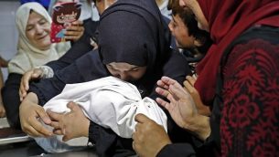 والدة ليلى الغندور، طفلة رضيعة فلسطينية تبلغ من العمر 8 أشهر التي توفيت جراء استنشاقها للغاز المسيل للدموع، بحسب وزارة الصحة التابعة لحركة حماس في غزة، تختضن جثة طفلتها في مكان حفظ الجثث في مستشفى ’الشفاء’ في مدينة غزة في 15 مايو، 2018. في 16 مايو، قالت الوزارة إنه لم يتم تحديد سبب الوفاة بصورة قاطعة. (AFP/Thomas Coex)