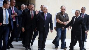 رئيس السلطة الفلسطينية محمود عباس (وسط الصورة) يلوح للكاميرات وهو يغادر المستشفى في رام الله في الضفة الغربية، 28 مايو، 2018. (AFP PHOTO / ABBAS MOMANI)