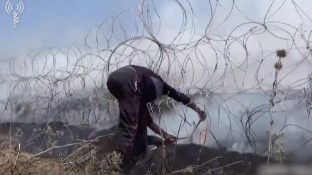 صورة توضيحية: فلسطينيون يستخدمون مقص اسلاك لاختراق السياج الحدودي في صورة نشرها الجيش الإسرائيلي في 14 مايو 2018 (Israel Defense Forces)