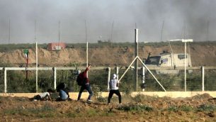 رجل فلسطيني يرمي حجرا باتجاه القوات الإسرائيلية خلال مظاهرة عند حدود غزة، 1 يونيو 2018 (AFP/ Mahmud Hams)