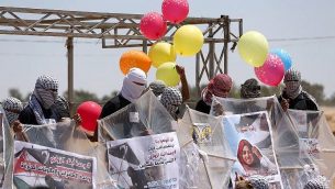 فلسطينيون يحّملون طائرات ورقية وبالونات بمواد حارقة من أجل إطلاقها باتجاه إسرائيل، على الحدود بين غزة وإسرائيل في البريج، وسط قطاع غزة، 14 يونيو، 2018. (AFP Photo/Mahmud Hams)