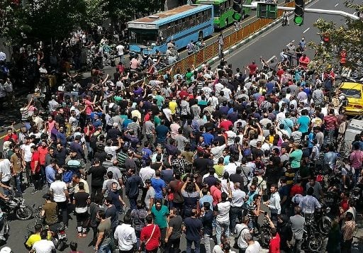 متظاهرون إيرانيون يرفعون شعارات خلال مظاهرة بوسط طهران في 25 يونيو عام 2018. نظم التجار في سوق البازار الكبير بالعاصمة الإيرانية إضرابا نادرا احتجاجا على انهيار الريال في سوق الصرف الأجنبي مع خروج المتظاهرين أيضا إلى الشوارع. (ATTA KENARE / AFP)