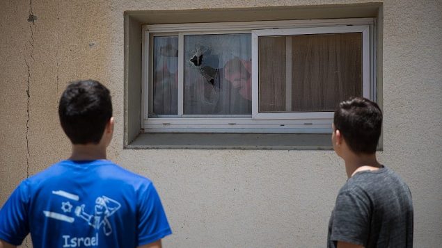 إسرائيليان في كيبوتس بالقرب من غزة يتفحصان مكان سقوط صاروخ تم إطلاقه من غزة بالقرب من منازل، ما تسبب بتحطيم نوافذ، 20 يونيو، 2018. (Yonatan Sindel/Flash90) إسرائيليان في كيبوتس بالقرب من غزة يتفحصان مكان سقوط صاروخ تم إطلاقه من غزة بالقرب من منازل، ما تسبب بتحطيم نوافذ، 20 يونيو، 2018. (Yonatan Sindel/Flash90)