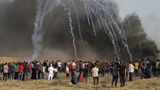 صورة تم التقاطها في 13 يوليو 2018 تظهر عبوات الغاز المسيل للدموع التي أطلقتها القوات الإسرائيلية وهبطت وسط المتظاهرين خلال مظاهرة على طول الحدود مع إسرائيل شرق مدينة غزة. (AFP/Mahmud Hams)