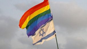 متظاهرون يرفعون العلم الإسرائيلي وعلم الفخر في مظاهرة في تل أبيب في 22 يوليو 2018، احتجاجا على قانون الحمل البديل الجديد الذي لا يشمل الأزواج المثليين. (AFP PHOTO / JACK GUEZ)