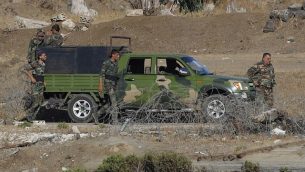 صورة تم التقاطها في 26 يوليو، 2018، بالقرب من كيبوتس عين زيفان في الجانب الإسرائيلي من هضبة الجولان، لجنود من الجيش السوري يستعيدون السيطرة على مواقع على طول الحدود بين سوريا وإسرائيل. (AFP Photo/Jack Guez)