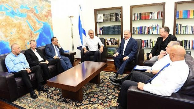 رئيس الوزراء بينيامين نتنياهو (وسط-يمين) خلال لقاء جمعه بوزير المالية موشيه كحلون (وسط-يسار) ووزير الاتصالات أيوب قرا (الثالث من اليسار) ووزير السياح ياريف ليفين (الثاني من اليسار)  وعضو الكنيست عن حزب ’كولانو’ أكرم حسون (من اليسار) وعضو الكنيست عن حزب ’إسرائيل بيتنا’ حمد عمار (من اليمين) ووزير الدفاع أفيغدور ليبرمان (الثاني من اليمين) وكبير موظفي نتنياهو، يوآف هوروفيتس (الثالث من اليمين) في 26 يوليو، 2018. (Haim Tzach/GPO)