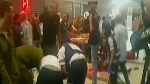 مسعفون يعالجون الضحايا بعد هجوم في محطة بئر السبع المركزية للحافلات في 18 أكتوبر 2015. (screen capture: Channel 2)