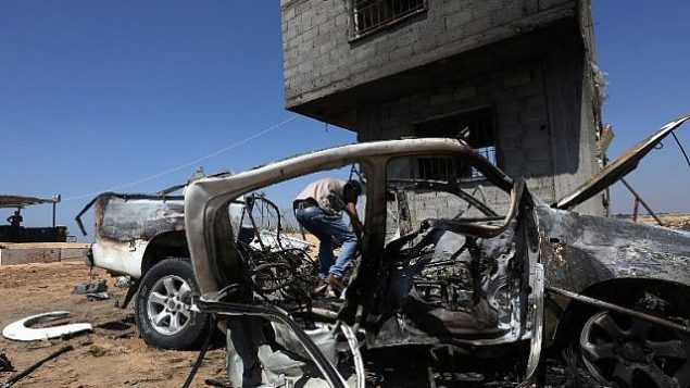 رجل فلسطيني يتفقد مركبة سيارة مدمرة بعد غارة جوية إسرائيلية في بيت لاهيا، شمال قطاع غزة، في 5 أغسطس، 2018. (AFP/ MAHMUD HAMS)