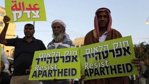 مواطنون إسرائيليون عرب يحملون لافتات خلال مظاهرة احتجاجية على قانون الدولة القومية في تل أبيب، 11 أغسطس، 2018.  (AFP/ Ahmad GHARABLI)