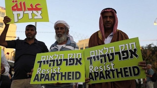 مواطنون إسرائيليون عرب يحملون لافتات خلال مظاهرة احتجاجية على قانون الدولة القومية في تل أبيب، 11 أغسطس، 2018.  (AFP/ Ahmad GHARABLI)