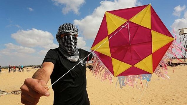 محتج فلسطيني يقوم بإطلاق طائرة ورقية محملة بمواد حارقة باتجاه إسرائيل خلال مظاهرة على الحدود مع إسرائيل، شرقي مدينة رفح في جنوب قطاع غزة، 29 يونيو، 2018. (Abed Rahim Khatib/Flash90)