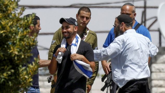 إيلور عزاريا، مركز، يزور مدينة الخليل في الضفة الغربية بعد اطلاق سراحه من السجن، حيث قضى عقوبة بتهمة القتل غير المتعمد عام 2016 لمعتدي فلسطيني في المدينة خلال خدمته العسكرية، 3 يوليو 2018 (Wisam Hashlamoun/Flash90) إيلور عزاريا، مركز، يزور مدينة الخليل في الضفة الغربية بعد اطلاق سراحه من السجن، حيث قضى عقوبة بتهمة القتل غير المتعمد عام 2016 لمعتدي فلسطيني في المدينة خلال خدمته العسكرية، 3 يوليو 2018 (Wisam Hashlamoun/Flash90)