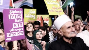مواطنون إسرائيليون عرب يتظاهرون ضد ’قانون الدولة القومية’ في تل أبيب، 11 أغسطس، يرقع بعضهم الأعلام الفلسطينية. (Tomer Neuberg/Flash90)